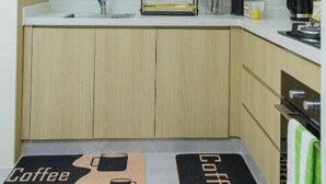 Een moderne keuken met witte kastjes, een roestvrijstalen spoelbak en een koffieapparaat.