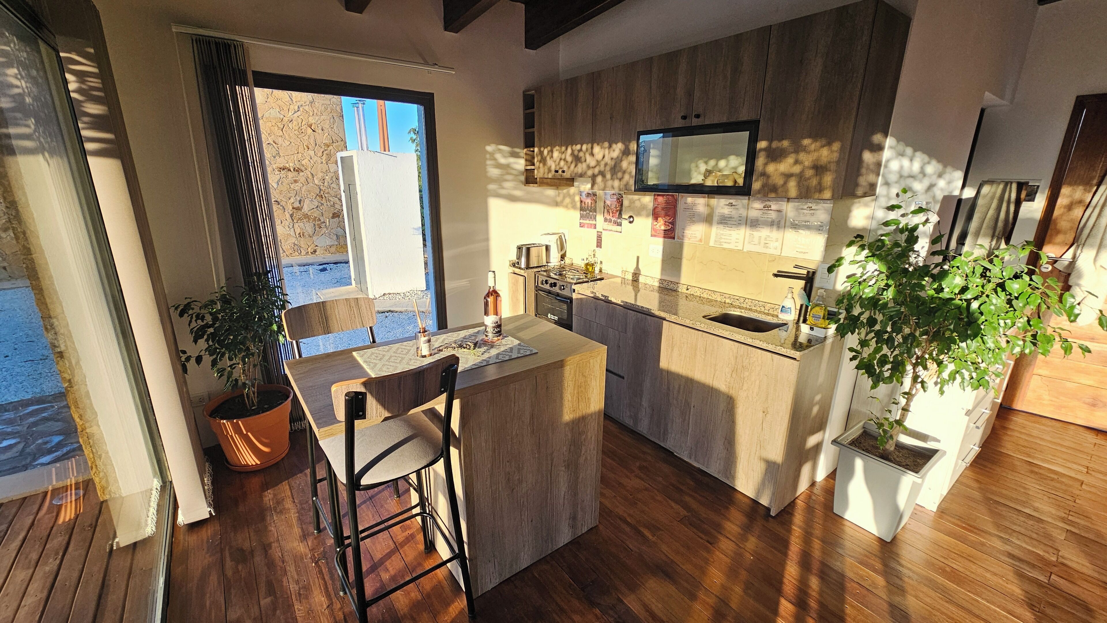 Una cocina moderna con una isla de madera, horno empotrado y televisor de pantalla plana montado sobre la isla.