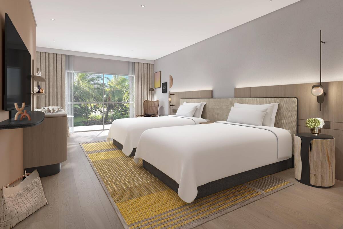 Habitación de hotel moderna con dos camas, televisión, balcón con vistas a zonas verdes y un ventanal grande.