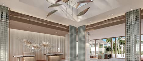 A spacious lobby with a high ceiling, a reception desk, and a seating area.