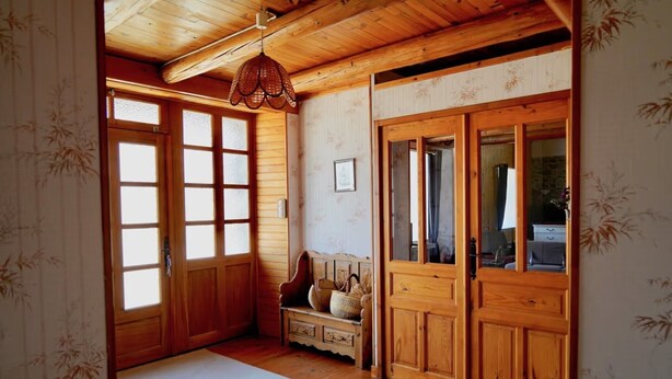 A traditional Japanese room with wooden doors, a tatami mat, a bench, and a hanging light fixture. - Holiday Home 'Les Cousines' with Mountain View, Private Terrace and Wi-Fi (Lavoûte-Chilhac)