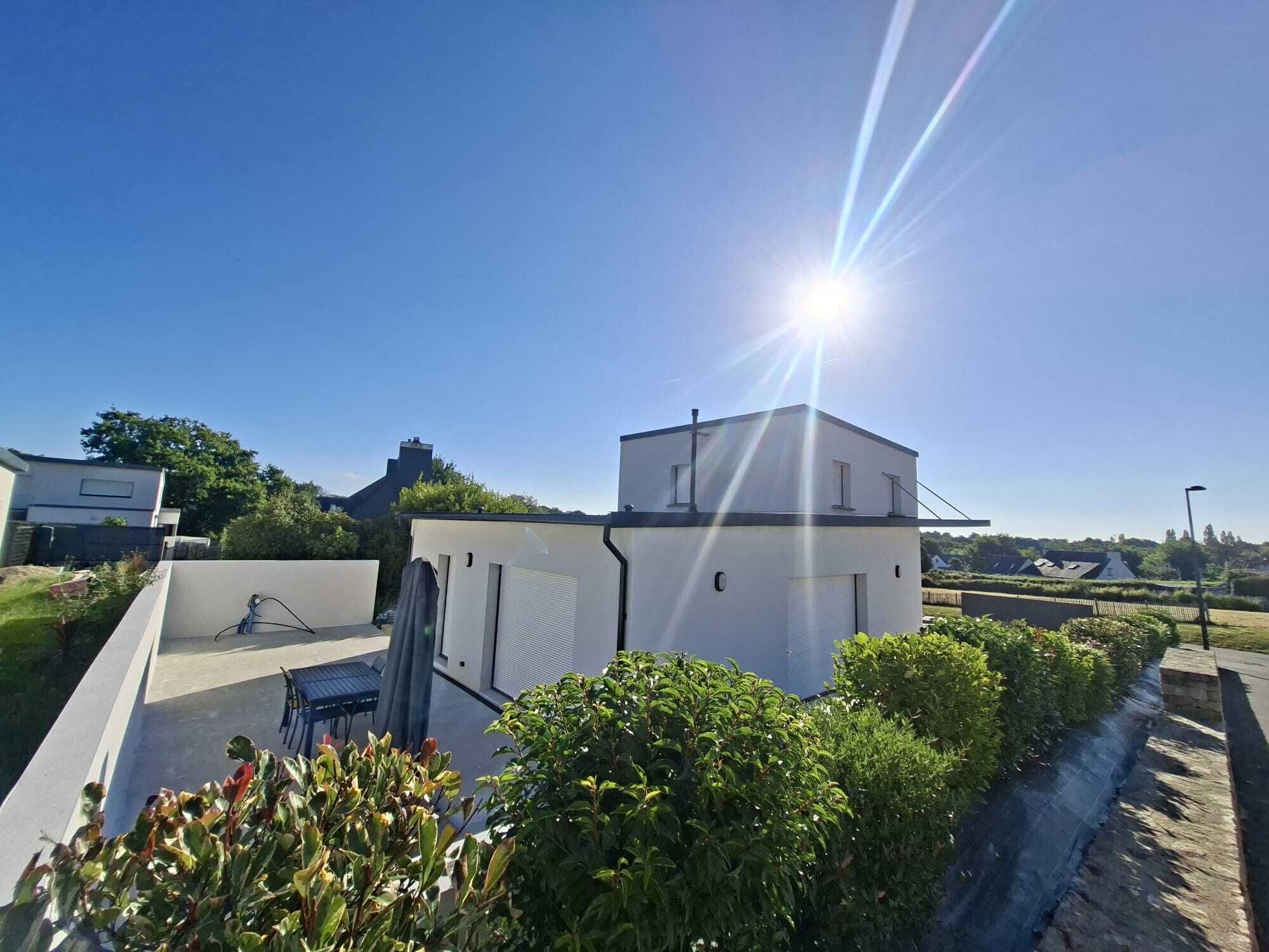 A rooftop with a flat surface, a small building, and surrounding greenery.