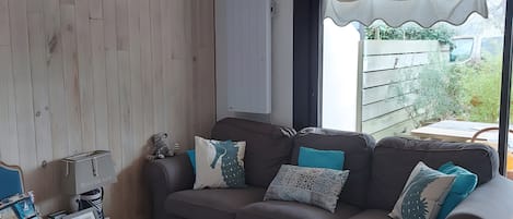 A cozy living room with a sofa, a coffee table, and a TV.