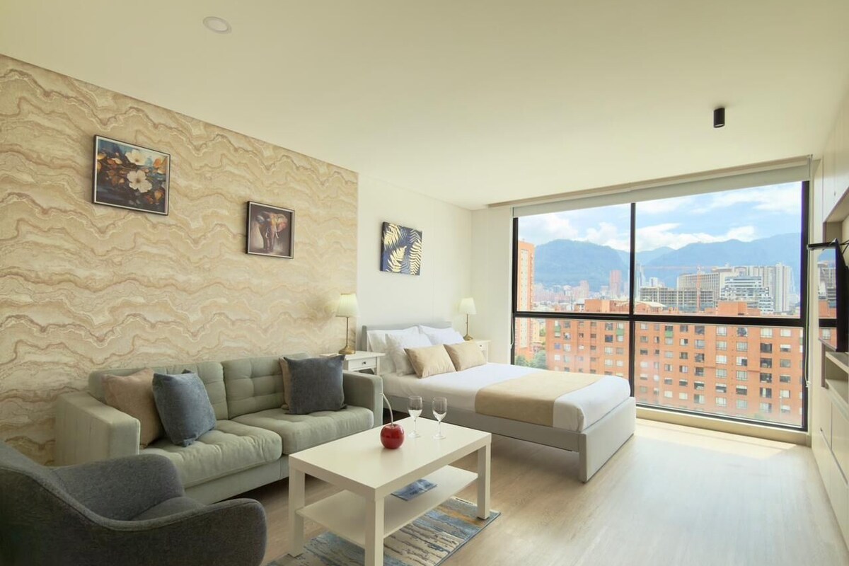 A modern living room with a sofa, a coffee table, and a bed. There is a large window with a city view.