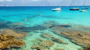 A coastal area with clear turquoise waters, rocky formations, and boats. - Apartment in Corsica Near Stunning Beach (Linguizzetta)