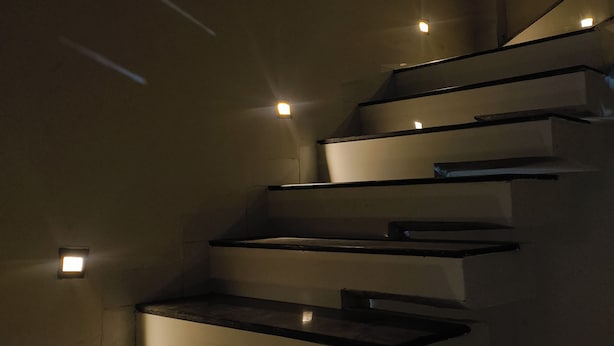 Una escalera moderna con iluminación integrada que da a una plataforma.