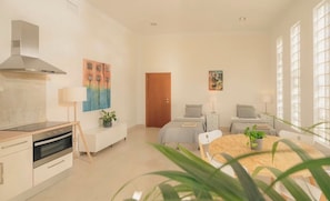 A modern, well-lit room with a kitchenette, a dining area, and a bed. - Maison du monde (Costa Adeje)