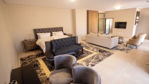 Une chambre moderne avec un grand lit, un canapé et un téléviseur.