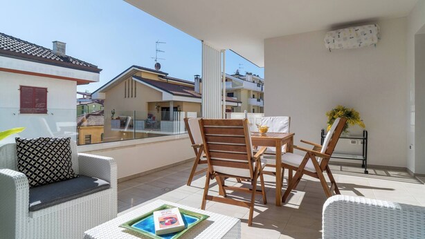 A balcony with wicker furniture, a table, and chairs. - Albamare (Alba Adriatica)