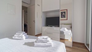 A hotel room with a bed, a TV, a wardrobe, and a bathroom visible through an open door. - Albamare (Alba Adriatica)