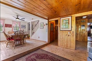 A wooden interior with a dining area, staircase, and a door leading to another room. - Bear Basin Lodge (McCall)