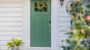 A green door with a wreath, a potted plant, and a doormat. - Fairmount Manor off of Lake Hollingsworth. Games, Gym, and Gather! Sleeps 8 (Lakeland)
