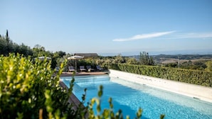 A swimming pool with lounge chairs and a view of the countryside. - Villa le Murate by MMega (Montaione)