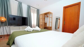 Una habitación de hotel con cama, televisión, armario y puerta.