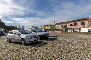 Un espace de stationnement avec des voitures et des bâtiments en arrière-plan.