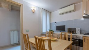 A modern kitchen with a dining table, chairs, a microwave, an oven, and a window.