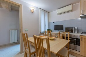 A modern kitchen with a dining table, chairs, a microwave, an oven, and a window. - GuestHost - A comfortable and welcoming 75 square meters apartment with a large courtyard and private entrance, perfect for six people, located on the ground floor of a renovated historic building facing the canal (NOT accessible by car).The property enj (Comacchio)