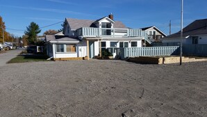 A two-story house with a balcony, a front porch, and a driveway.