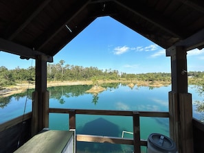 A wooden structure with a view of a calm lake and surrounding forest.