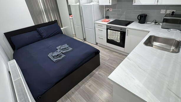 A compact hotel room with a bed, kitchenette, and a small bathroom. - Central London room w kitchen (Greater London)