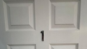 A white door with a rectangular panel design and a round doorknob. - London Clapham Common Room (Greater London)