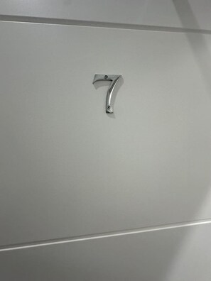 A metallic number 7 handle on a wall.