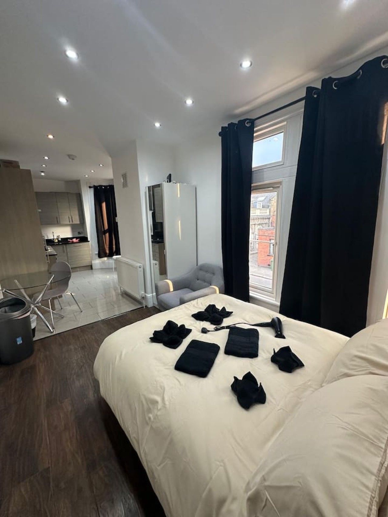 Ein Hotelzimmer mit einem großen Bett, einem Schreibtisch und Blick auf die Stadt.