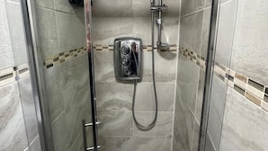 A glass-enclosed shower stall with a handheld showerhead and a wall-mounted control panel. - London zone 2 Private room (Greater London)