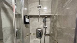 A walk-in shower with a glass door, a handheld showerhead, a wall-mounted faucet, and a control panel. - London zone 2 Private room (Greater London)