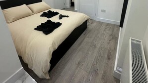 Une chambre moderne avec un lit, un radiateur et une porte.