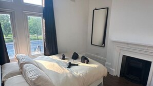 Ein Schlafzimmer mit einem großen Bett, einem Kamin und Blick aus dem Fenster.