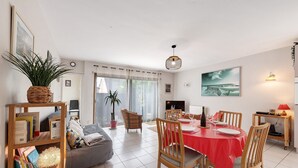 Un comedor con mantel rojo, sillas de madera y una mesa lista para cuatro comensales.