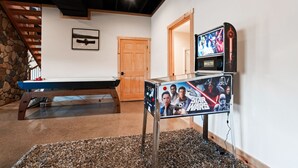 Ein Billardtisch, ein Star Wars Poster, eine Holztür und eine Steinwand.