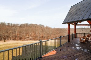 A wooden deck with a railing, a bench, and a solar panel structure.