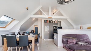 Un moderno loft con comedor, kitchenette y sofá.