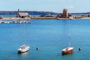 A harbor with boats, a lighthouse, and a building with a tower. - The Sea, the Sky, and the Beach (Camaret-sur-Mer)