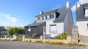 Un immeuble résidentiel doté d’un balcon, d’un garage et d’un mur en pierre.
