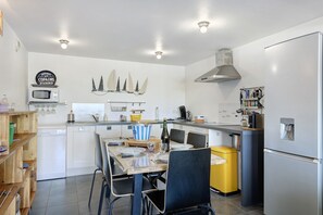 Une cuisine moderne équipée d’une table à manger, de chaises, d’un four à micro-ondes et d’un réfrigérateur.