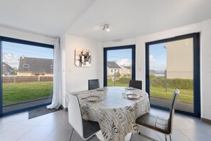 Un comedor con mesa, sillas y vistas al exterior.