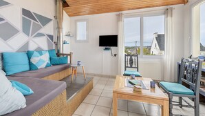 A modern living room with a sofa, a table, and chairs, a television, and large windows. - Sea View, Authentic Fisherman's House (Camaret-sur-Mer)