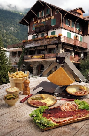 A wooden building with balconies and a sign that reads 'Hotel Malcovert.'. hotel le Malgovert