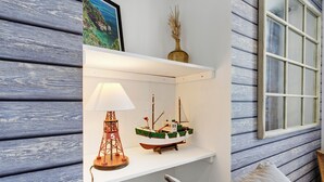 Ein Regal mit einem Schiffmodell, einer Lampe und einer Vase.