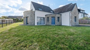 A modern house with a stone facade, large windows, and a well-maintained lawn. - Magical Moments by the Sea (Camaret-sur-Mer)