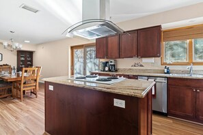 Una cocina moderna con armarios de madera, encimera de granito y lavavajillas integrado.