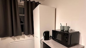 A compact kitchenette with a refrigerator, microwave, and coffee maker. - Central London 5 min to metro (Greater London)
