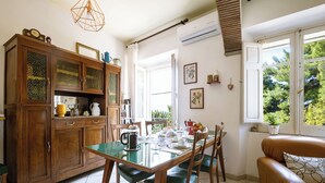 A dining area with a glass table, wooden chairs, and a brown leather sofa. - Explorer's room, cozy B&B Art Studio with watercolor lessos (Baunei)