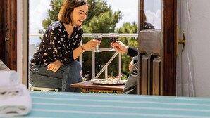 Two people toasting with drinks at a wooden table with a small tray of food. - Explorer's room, cozy B&B Art Studio with watercolor lessos (Baunei)