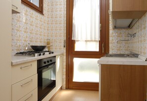 A kitchen with a stove, oven, and sink. - Cozy Villa With Garden (San Michele al Tagliamento)