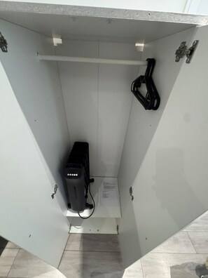 Ein weißes Stromverteilergehäuse mit einem schwarzen Gerät, einem Kabel und einer Beschriftung.