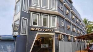 Un edificio de varios pisos con un llamativo letrero que dice 'Beach Front' en la entrada.